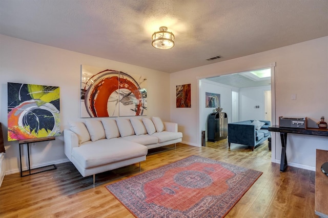 living room with hardwood / wood-style floors and a textured ceiling