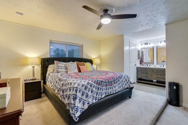 carpeted bedroom with ceiling fan, connected bathroom, and a textured ceiling