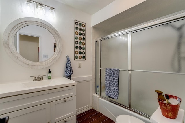 full bathroom featuring vanity, bath / shower combo with glass door, and toilet