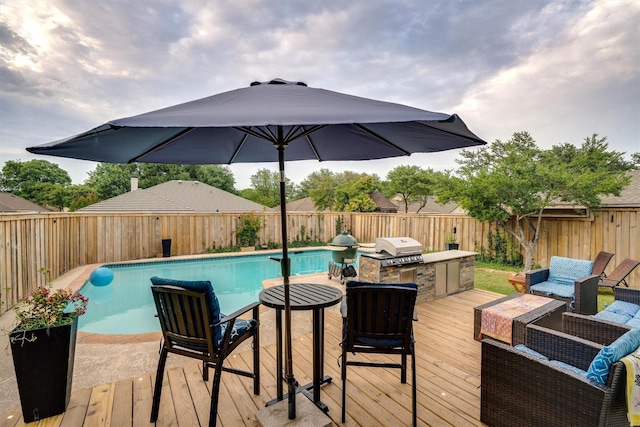 view of swimming pool with a wooden deck, grilling area, outdoor lounge area, and exterior kitchen