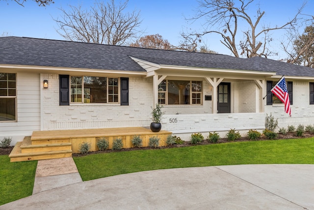 single story home with covered porch and a front lawn