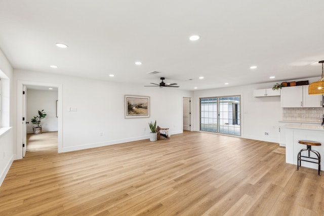 unfurnished living room with ceiling fan and light wood-type flooring