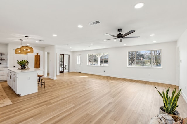 unfurnished living room featuring ceiling fan and light hardwood / wood-style flooring