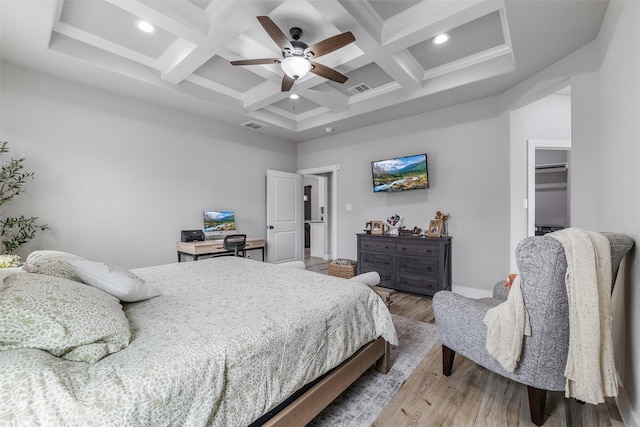 bedroom featuring coffered ceiling, light hardwood / wood-style floors, and beamed ceiling