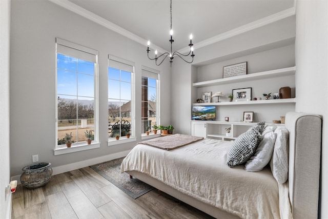 bedroom with hardwood / wood-style floors, a notable chandelier, and ornamental molding