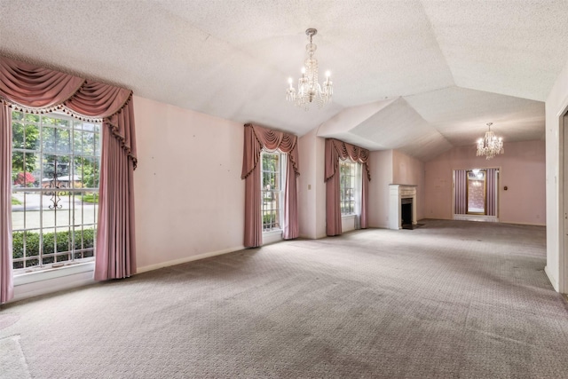 unfurnished living room featuring an inviting chandelier, vaulted ceiling, a textured ceiling, and carpet flooring