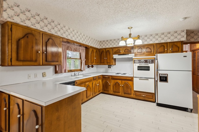 kitchen with sink, an inviting chandelier, decorative light fixtures, a textured ceiling, and white appliances