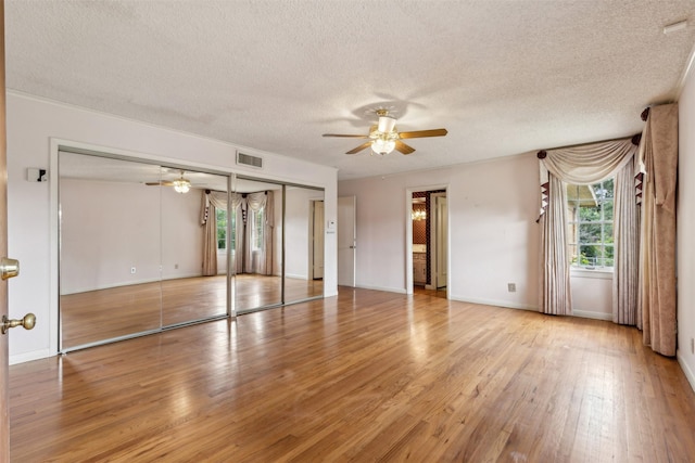 interior space featuring ceiling fan, a textured ceiling, and light wood-type flooring