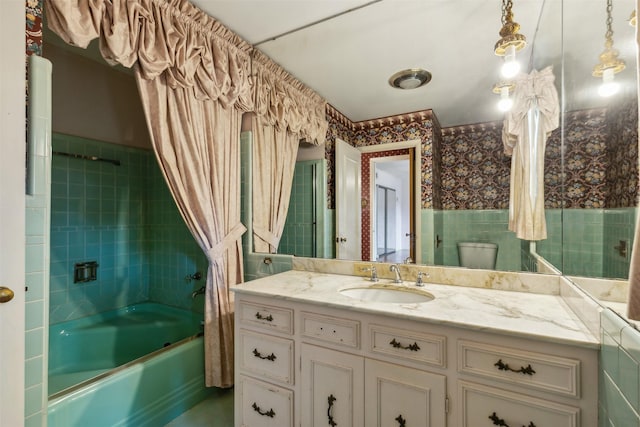 full bathroom featuring tiled shower / bath, vanity, and toilet