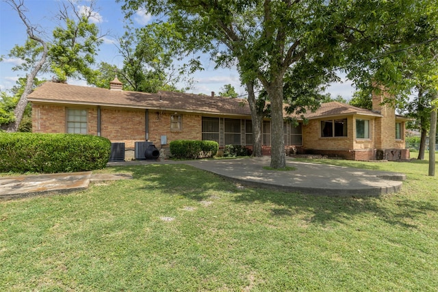 back of property with a lawn and central air condition unit