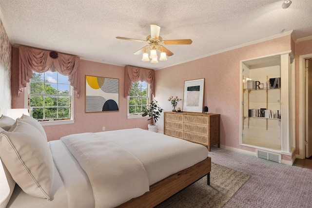 carpeted bedroom with ornamental molding, ceiling fan, and a textured ceiling