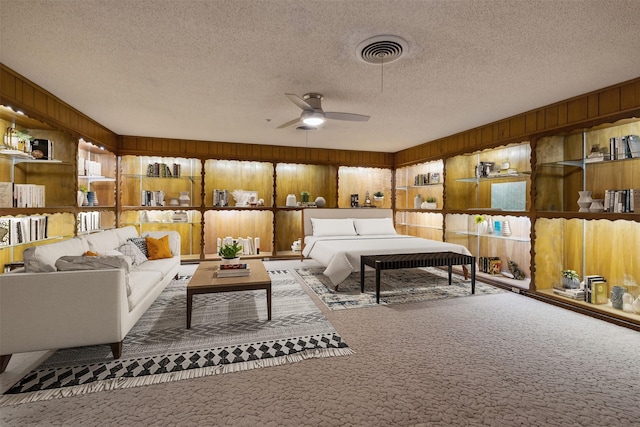 carpeted bedroom with wooden walls and a textured ceiling