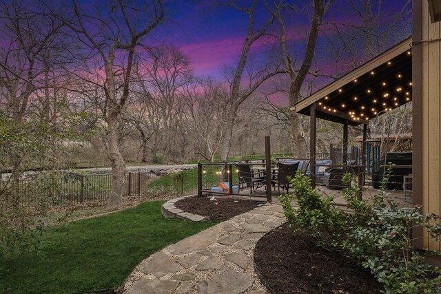 yard at dusk featuring a patio area