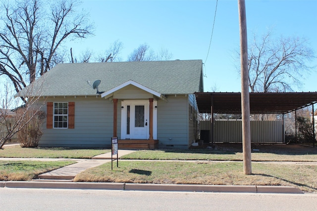 231 N 5th Ave, Munday, TX 76371 - view of front of property with a carport, central AC unit, and a front yard
