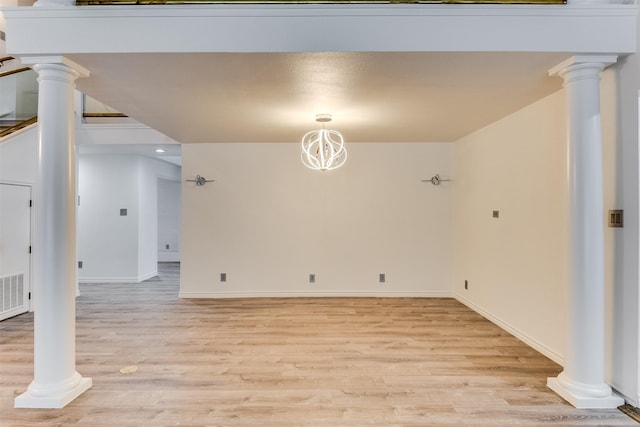 interior space featuring a chandelier, light hardwood / wood-style floors, and decorative columns