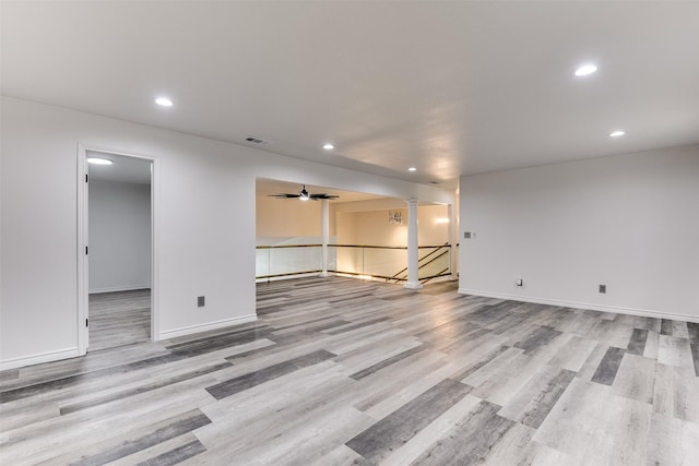 unfurnished room with ornate columns, ceiling fan, and light hardwood / wood-style flooring