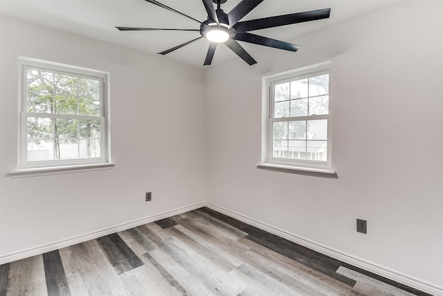 unfurnished room with hardwood / wood-style flooring, ceiling fan, and a wealth of natural light