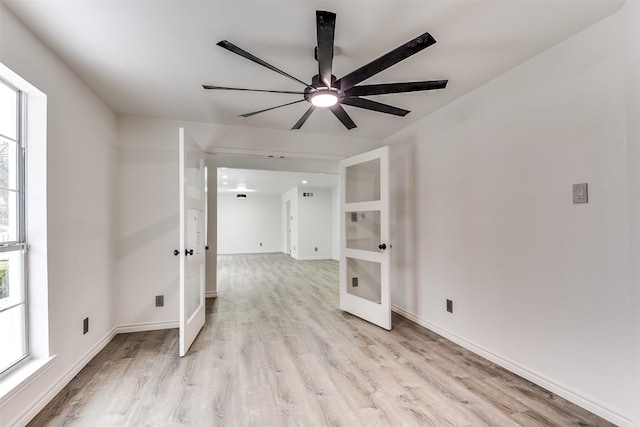 empty room featuring ceiling fan, plenty of natural light, and light hardwood / wood-style floors