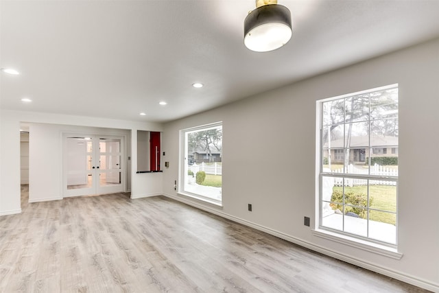 unfurnished living room featuring light hardwood / wood-style floors and french doors