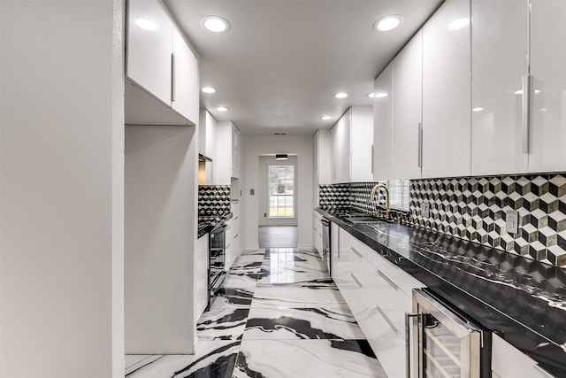 kitchen featuring tasteful backsplash, sink, and white cabinets