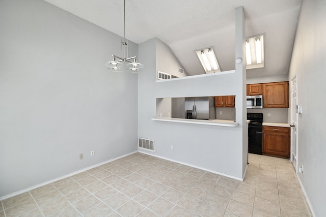 kitchen featuring lofted ceiling, an inviting chandelier, hanging light fixtures, light tile patterned floors, and appliances with stainless steel finishes