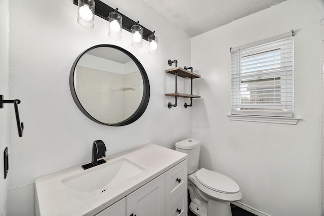 bathroom featuring vanity, a textured ceiling, and toilet