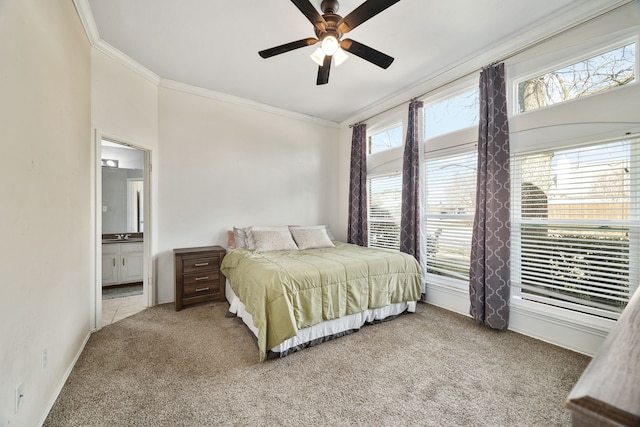 carpeted bedroom with crown molding, ensuite bath, and ceiling fan