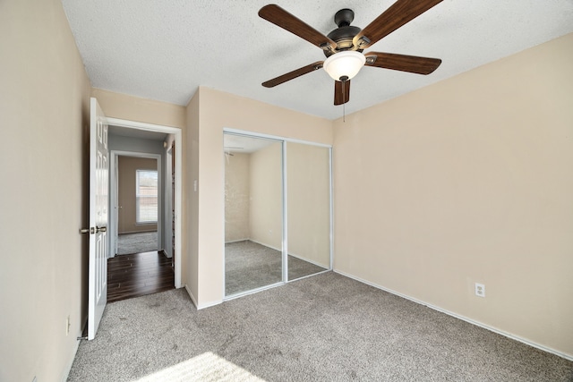 unfurnished bedroom featuring ceiling fan, a closet, carpet, and a textured ceiling