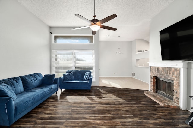 living room with dark hardwood / wood-style flooring, a brick fireplace, a textured ceiling, and ceiling fan