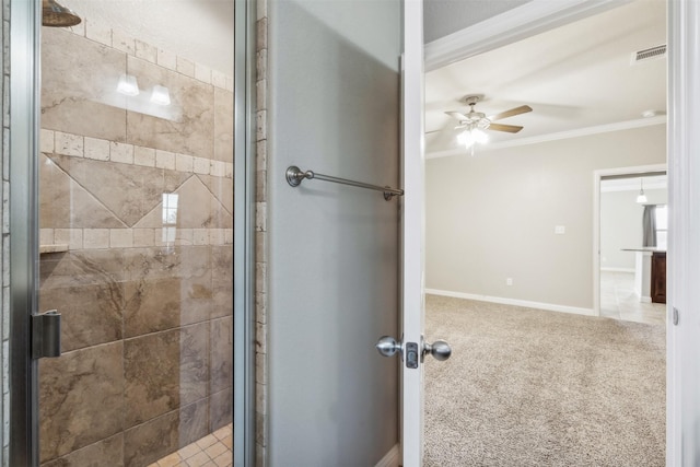 bathroom featuring ceiling fan, ornamental molding, and a shower with door