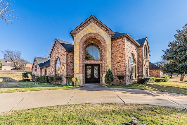 view of front of home with a front yard and french doors