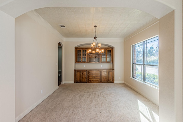 bar featuring hanging light fixtures, crown molding, light colored carpet, and a notable chandelier