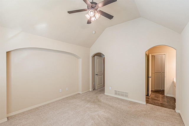 spare room featuring ceiling fan, light colored carpet, and vaulted ceiling