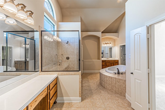 bathroom featuring tile patterned flooring, shower with separate bathtub, lofted ceiling, and vanity