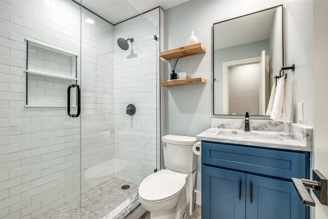 bathroom with vanity, toilet, and a shower with door