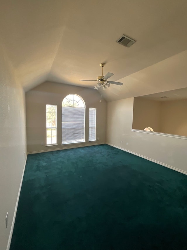 carpeted empty room featuring ceiling fan and vaulted ceiling