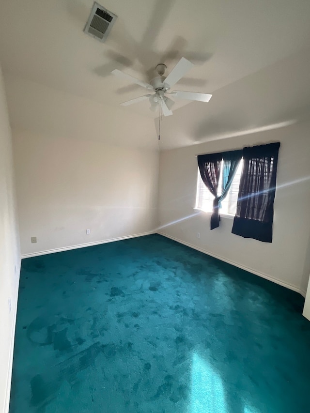 spare room featuring ceiling fan and carpet