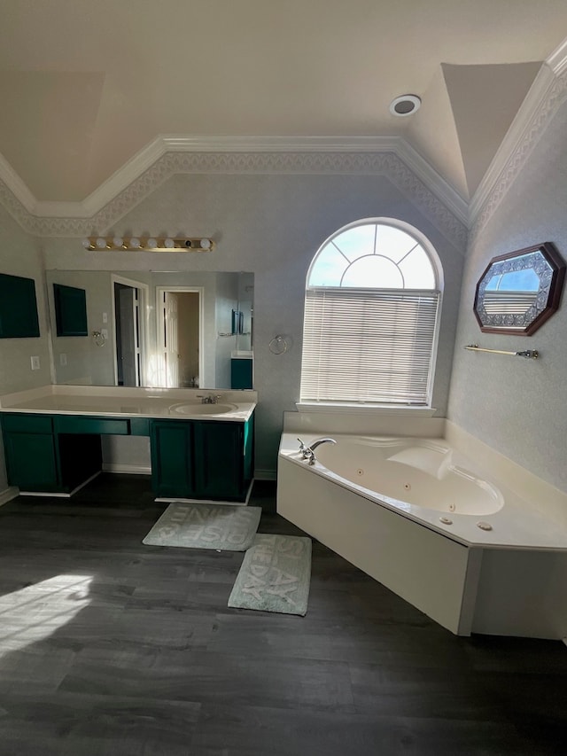 bathroom with a tub to relax in, crown molding, vaulted ceiling, vanity, and hardwood / wood-style flooring