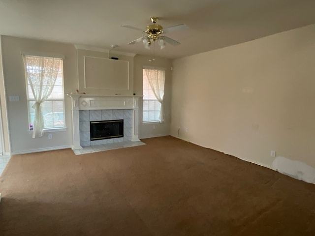 unfurnished living room with ceiling fan, light colored carpet, a fireplace, and a wealth of natural light