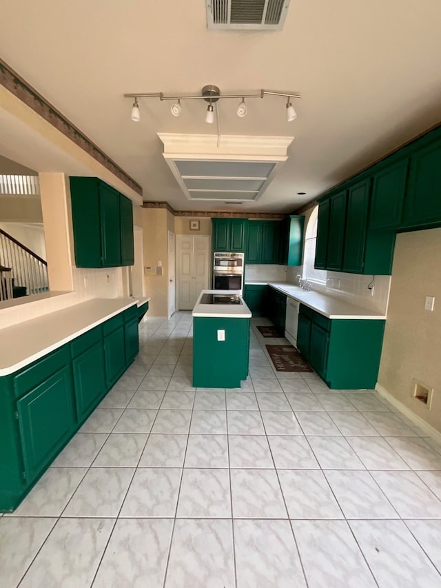 kitchen with sink, a center island, dishwasher, green cabinets, and stainless steel double oven