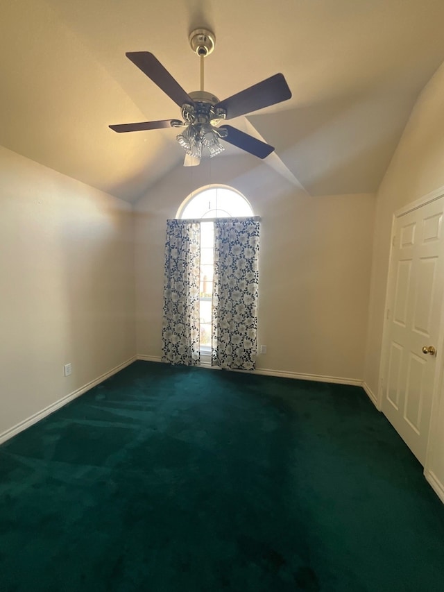 carpeted empty room with ceiling fan and vaulted ceiling