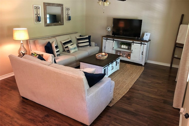 living room featuring dark wood-type flooring and ceiling fan