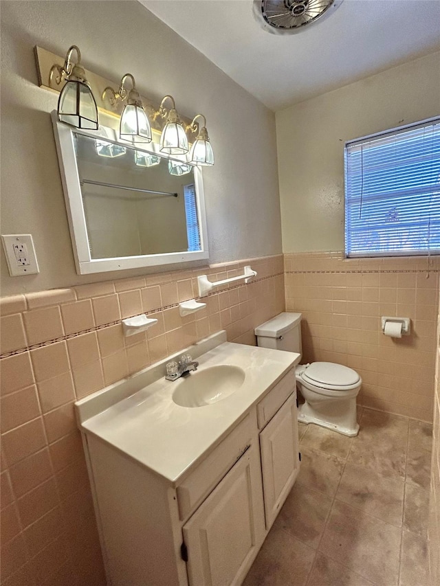 bathroom featuring vanity, tile walls, tile patterned floors, and toilet