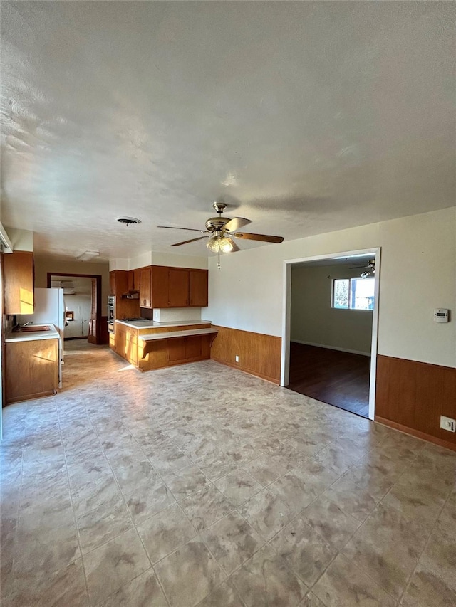 interior space with wooden walls and ceiling fan