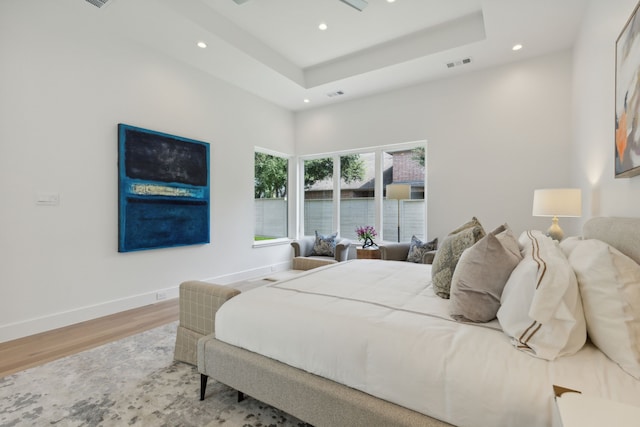 bedroom featuring hardwood / wood-style floors and a tray ceiling