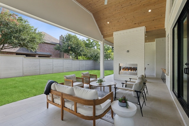 view of patio with an outdoor living space with a fireplace