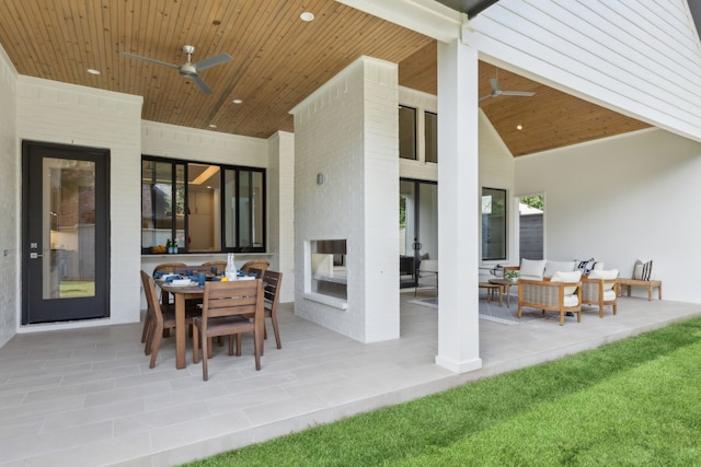 view of patio with an outdoor living space with a fireplace and ceiling fan