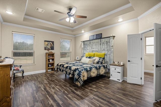 bedroom featuring multiple windows, crown molding, dark wood-type flooring, and a tray ceiling