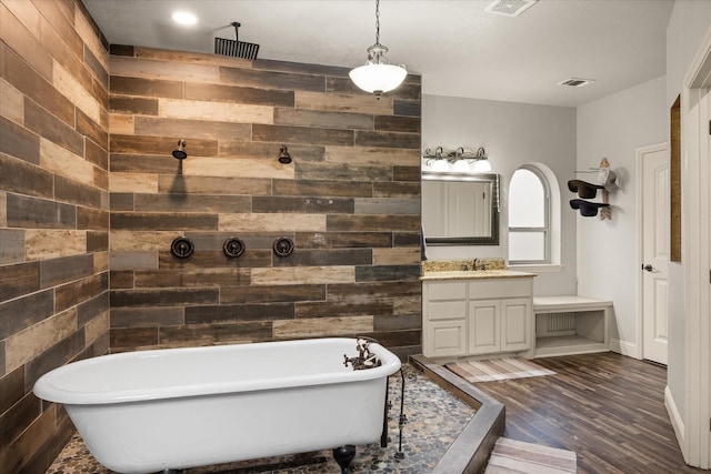 bathroom featuring vanity, wood-type flooring, a bath, and wood walls