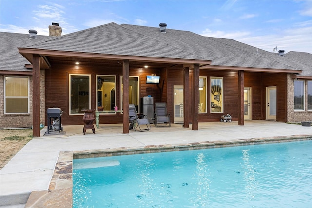 view of swimming pool with a grill and a patio